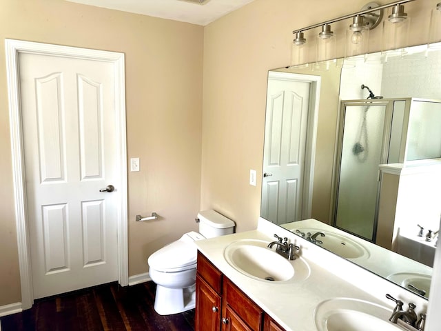 bathroom featuring hardwood / wood-style flooring, dual vanity, and toilet