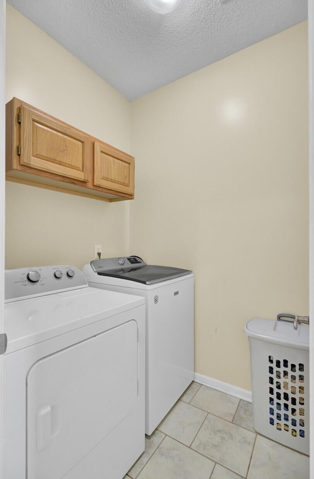103 Trimley Ct, Goose Creek, SC 29445 - laundry area featuring washer and dryer, cabinet space, baseboards, a textured ceiling, and light tile patterned floors