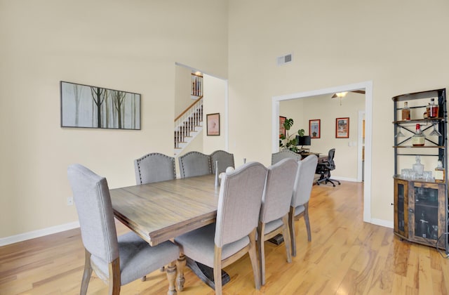 103 Trimley Ct, Goose Creek, SC 29445 - dining area featuring light wood-type flooring, stairway, baseboards, and a towering ceiling