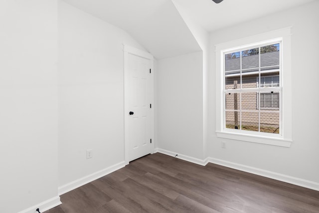 empty room featuring vaulted ceiling and dark hardwood / wood-style floors