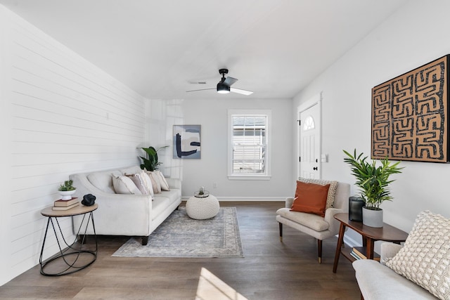 living room featuring ceiling fan and dark hardwood / wood-style floors