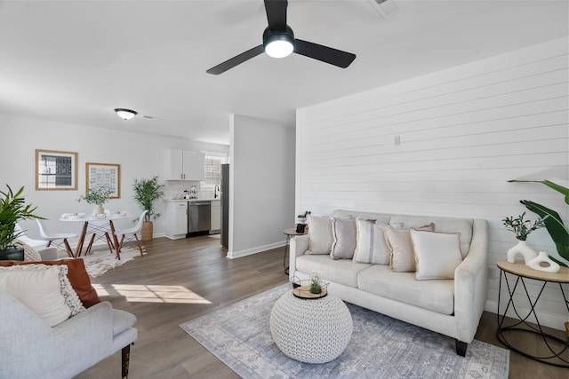 living room with ceiling fan and dark wood-type flooring