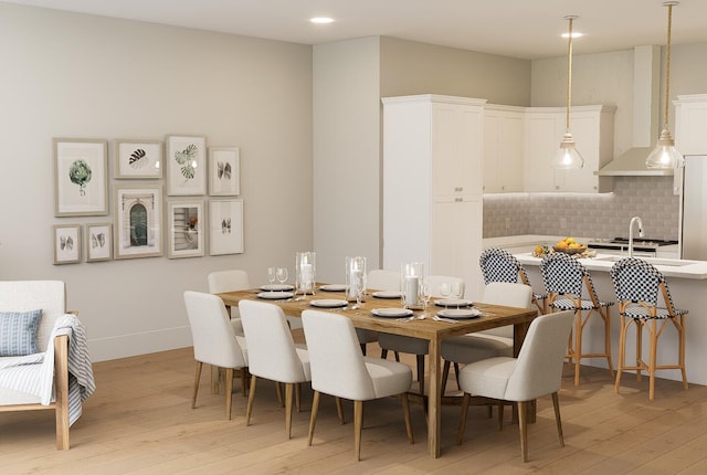 dining area featuring baseboards and light wood-style floors