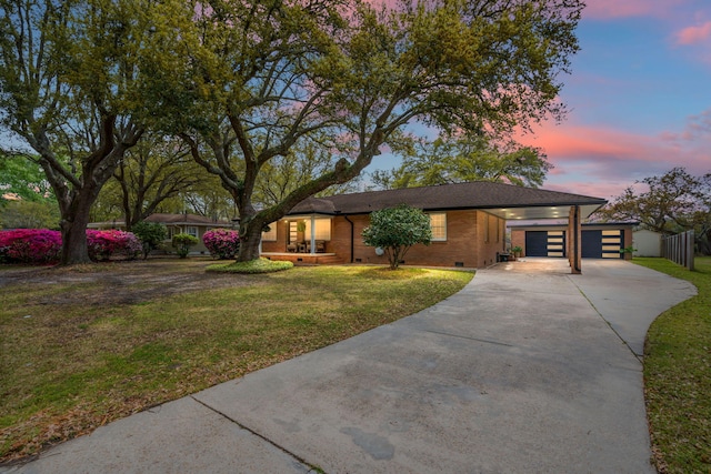 ranch-style home featuring fence, brick siding, a lawn, driveway, and a carport