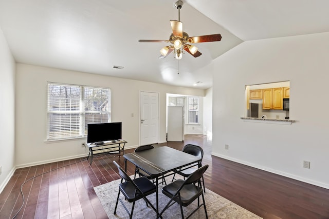 dining room with vaulted ceiling, ceiling fan, and dark hardwood / wood-style floors