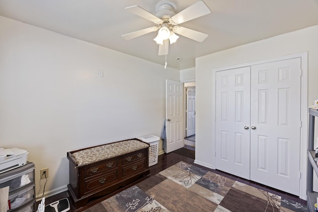 bedroom featuring ceiling fan, a closet, and dark wood-type flooring