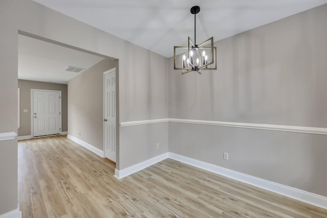 unfurnished dining area with light wood-type flooring and a notable chandelier