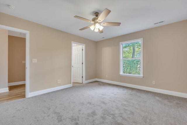 spare room featuring light colored carpet and ceiling fan