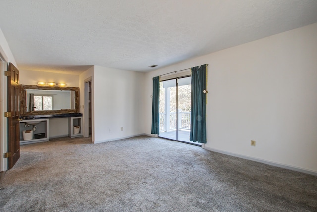 unfurnished living room featuring carpet floors, visible vents, baseboards, and a textured ceiling