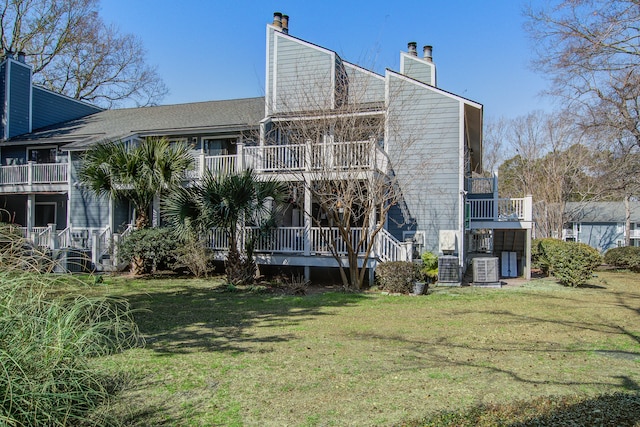 back of property featuring a chimney and a lawn