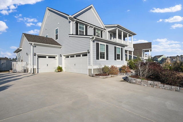 view of side of home with driveway and a balcony