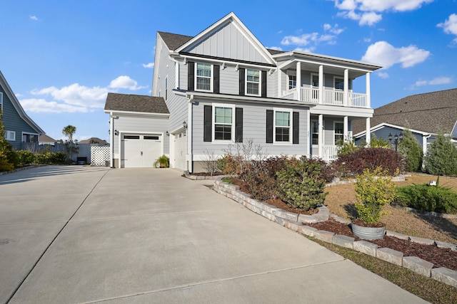 view of front of property with a garage, concrete driveway, a balcony, fence, and board and batten siding