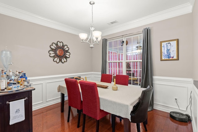 3364 Middlesboro Ave, Summerville, SC 29485 - dining space with crown molding, a chandelier, dark wood finished floors, a wainscoted wall, and a decorative wall
