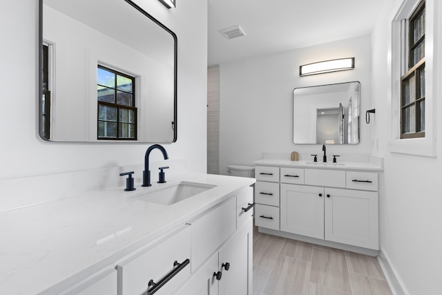 1320 Bresee St, Charleston, SC 29412 - bathroom featuring two vanities, toilet, and baseboards