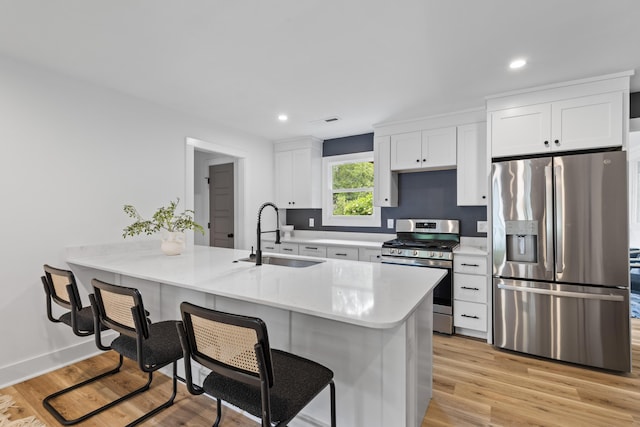 1320 Bresee St, Charleston, SC 29412 - kitchen with stainless steel appliances, a sink, a kitchen breakfast bar, white cabinetry, and light countertops