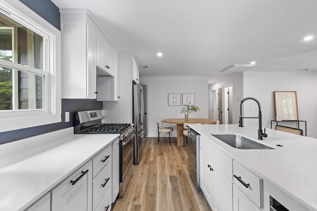 1320 Bresee St, Charleston, SC 29412 - kitchen with stainless steel appliances, a sink, recessed lighting, white cabinetry, and light wood finished floors