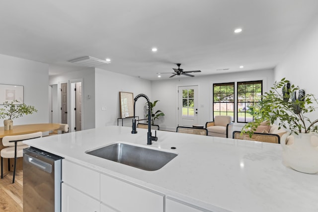 1320 Bresee St, Charleston, SC 29412 - kitchen with stainless steel dishwasher, a sink, white cabinets, recessed lighting, and light stone countertops