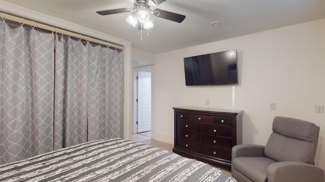 tiled bedroom featuring ceiling fan and a closet