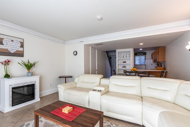 living room with light tile patterned flooring, a high end fireplace, crown molding, and built in shelves