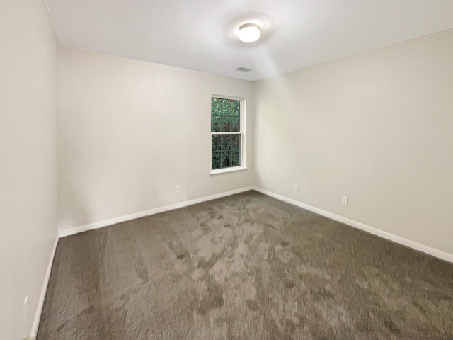 empty room featuring dark carpet