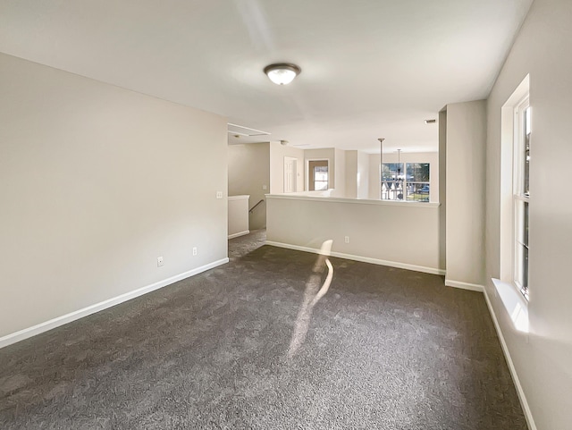 unfurnished room with dark carpet