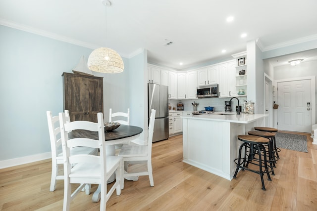 kitchen featuring light hardwood / wood-style flooring, white cabinets, stainless steel appliances, and sink