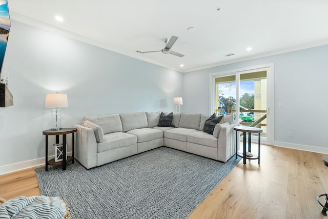 living room featuring ceiling fan, crown molding, and light wood-type flooring