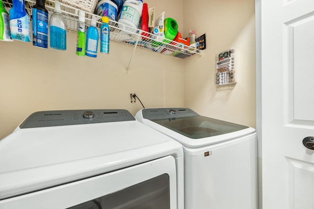 clothes washing area with washing machine and dryer