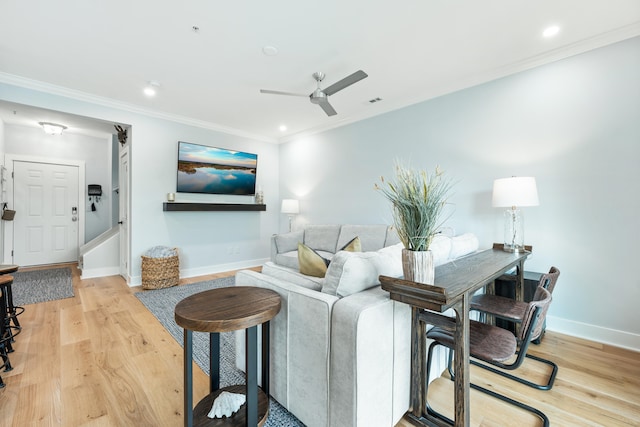 living room featuring ceiling fan, light hardwood / wood-style floors, and ornamental molding