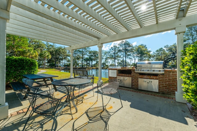 view of patio with an outdoor kitchen, a water view, a pergola, and grilling area