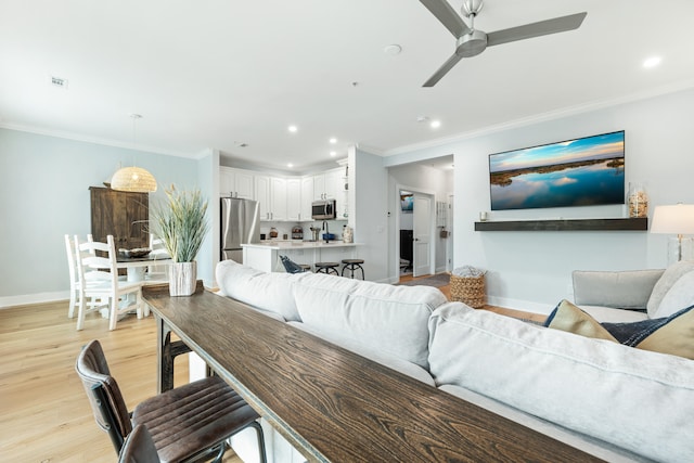 living room with ceiling fan, light hardwood / wood-style floors, and ornamental molding