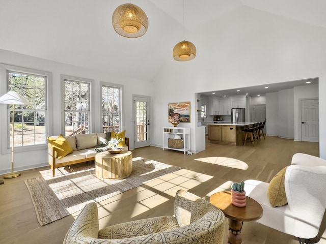 living area featuring light wood-style floors, recessed lighting, high vaulted ceiling, and baseboards