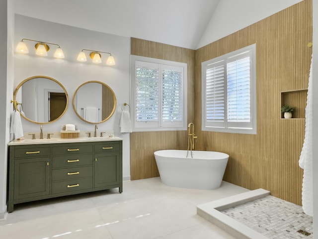 full bathroom with lofted ceiling, a freestanding bath, double vanity, and a sink