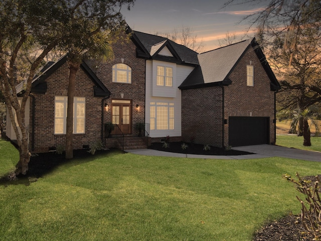 traditional-style house featuring aphalt driveway, a front yard, brick siding, and an attached garage