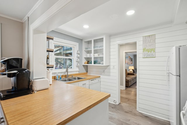 kitchen with ornamental molding, white appliances, sink, light hardwood / wood-style flooring, and white cabinets