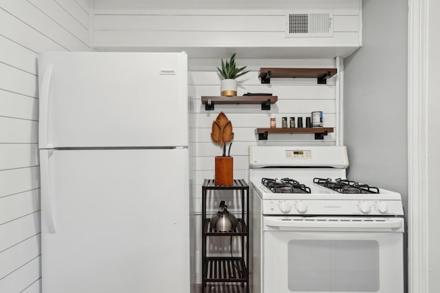 kitchen featuring white appliances and wooden walls