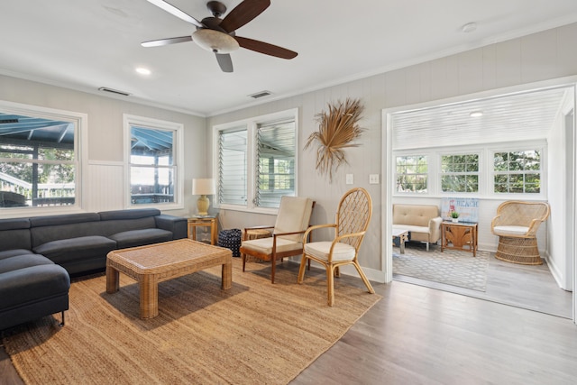 living room featuring light hardwood / wood-style flooring, ceiling fan, a healthy amount of sunlight, and crown molding