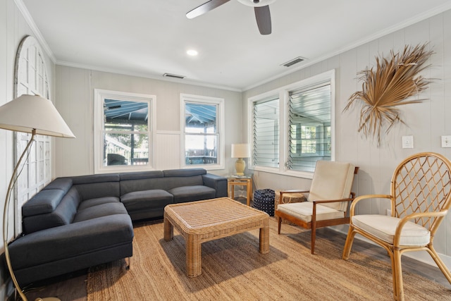 living room with crown molding, ceiling fan, and light wood-type flooring