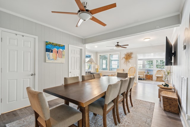 dining area featuring light wood-type flooring, ceiling fan, and ornamental molding