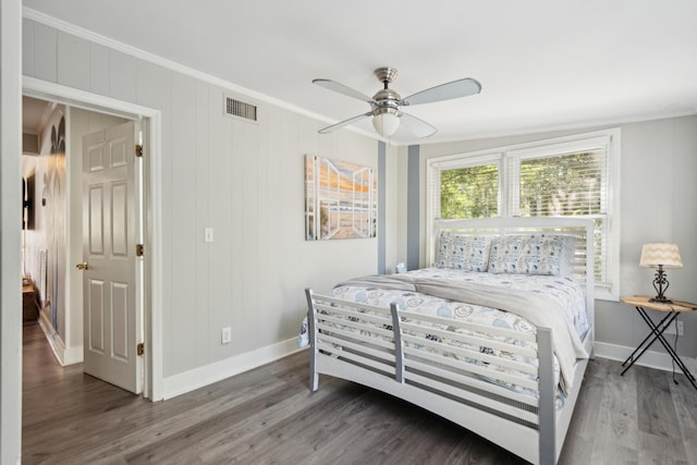 bedroom with dark hardwood / wood-style floors, ceiling fan, and ornamental molding