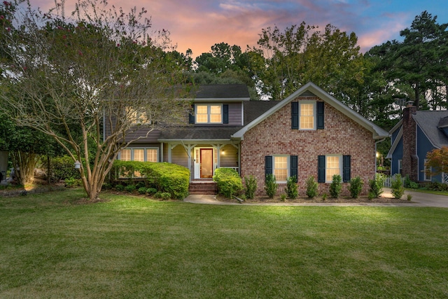 traditional home with brick siding and a yard