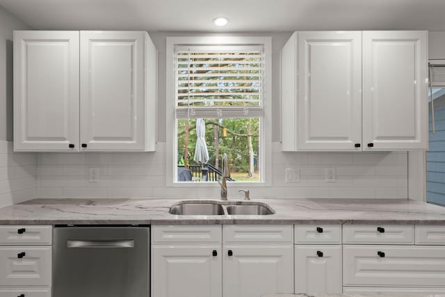 kitchen featuring decorative backsplash, white cabinetry, a sink, and dishwasher