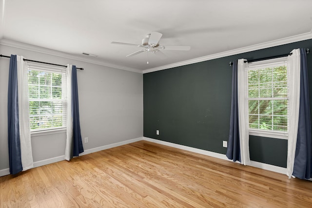 unfurnished room featuring light wood-type flooring, a ceiling fan, baseboards, and crown molding