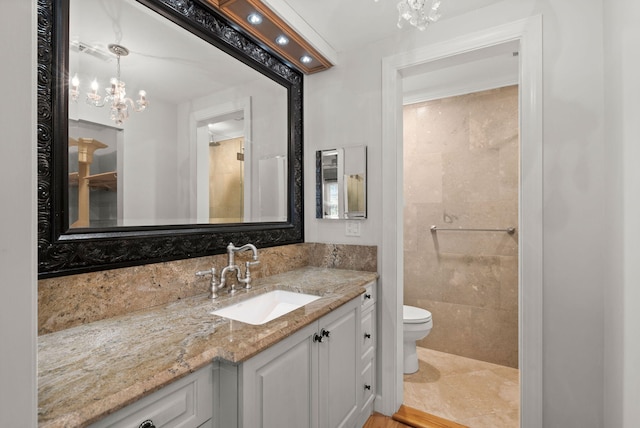 bathroom with a chandelier, visible vents, vanity, and toilet