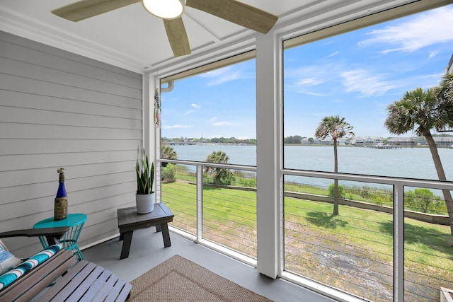 sunroom / solarium featuring a water view and ceiling fan