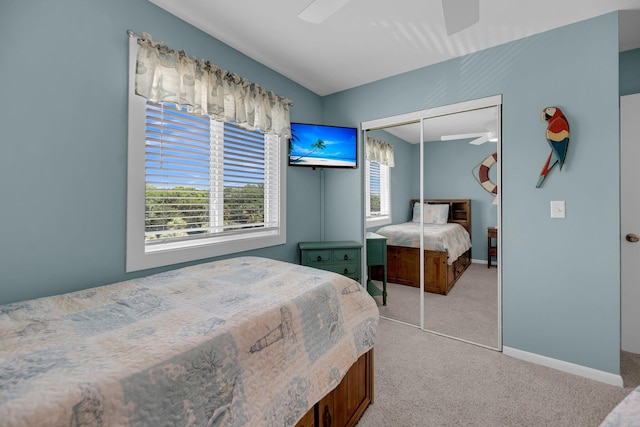 carpeted bedroom featuring ceiling fan and a closet