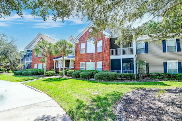 view of property featuring a front yard and a balcony