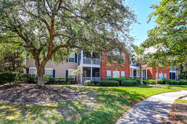 exterior space featuring a balcony and a front yard