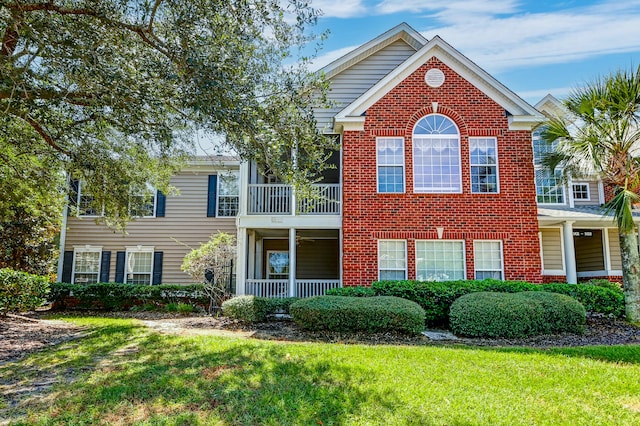 view of front of home featuring a balcony and a front yard