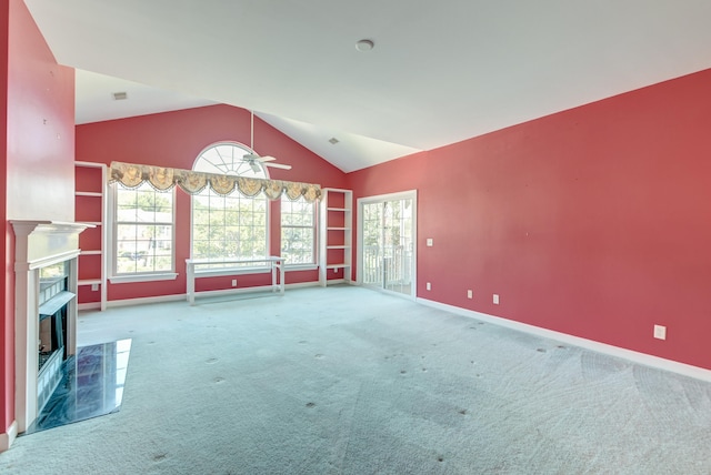 unfurnished living room with carpet floors, a tile fireplace, vaulted ceiling, and ceiling fan